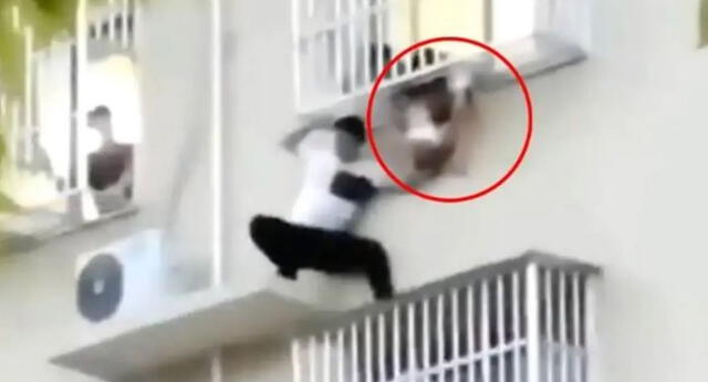 China: sujeto arriesga la vida para salvar a niña que casi cae del sexto piso.